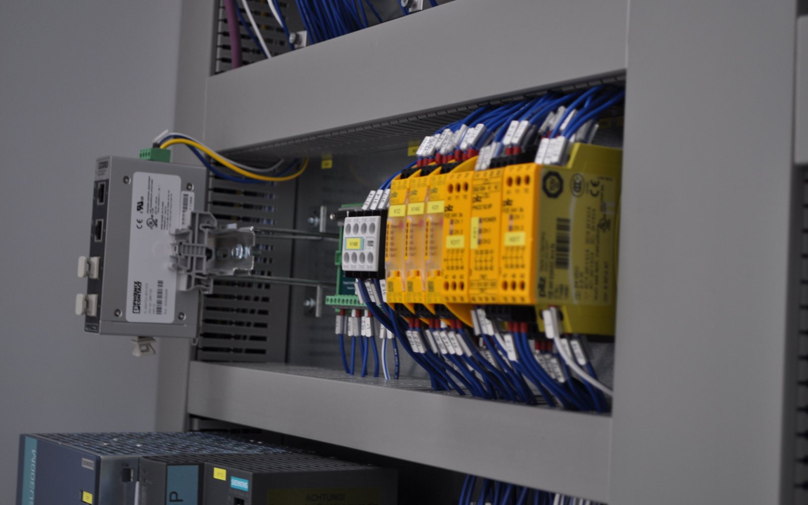 Alimentatore, PLC e moduli di sicurezza cablati su guida DIN in un quadro di automazione